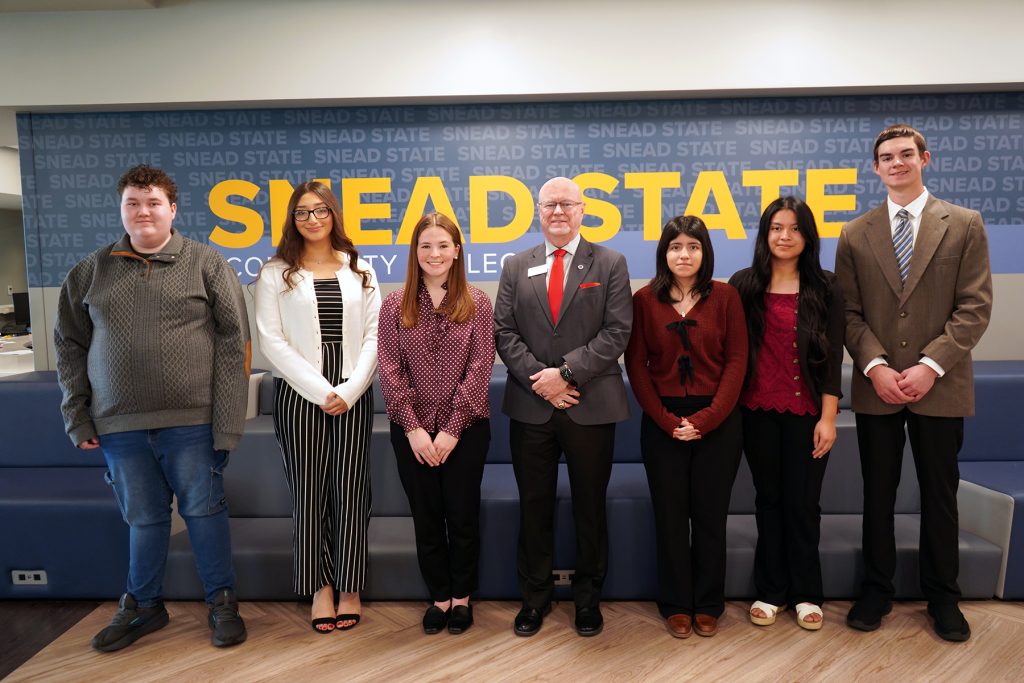 group of students standing with a college administrator