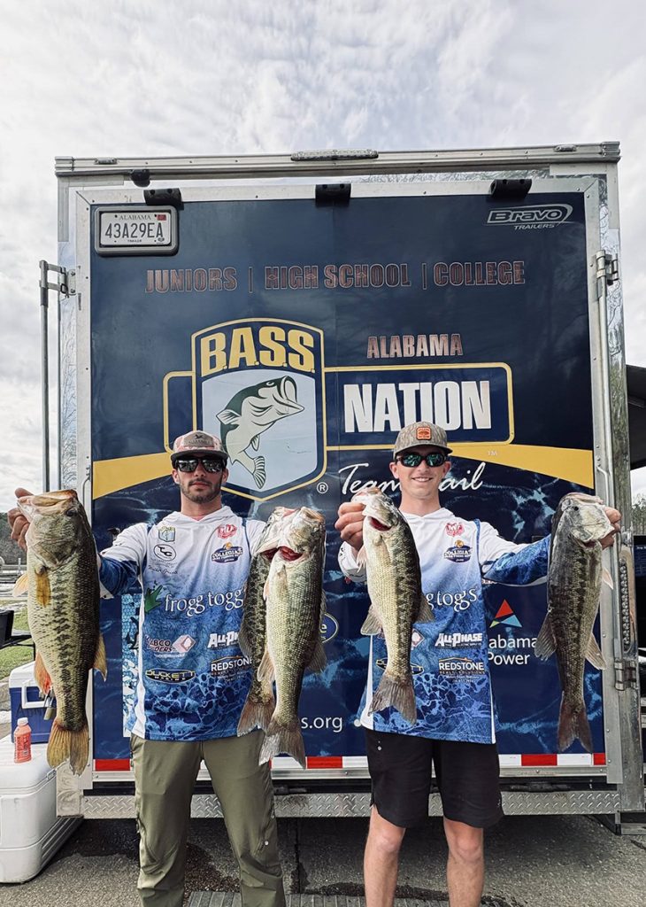 Two fishing anglers holding up their winning fish at a college tournament