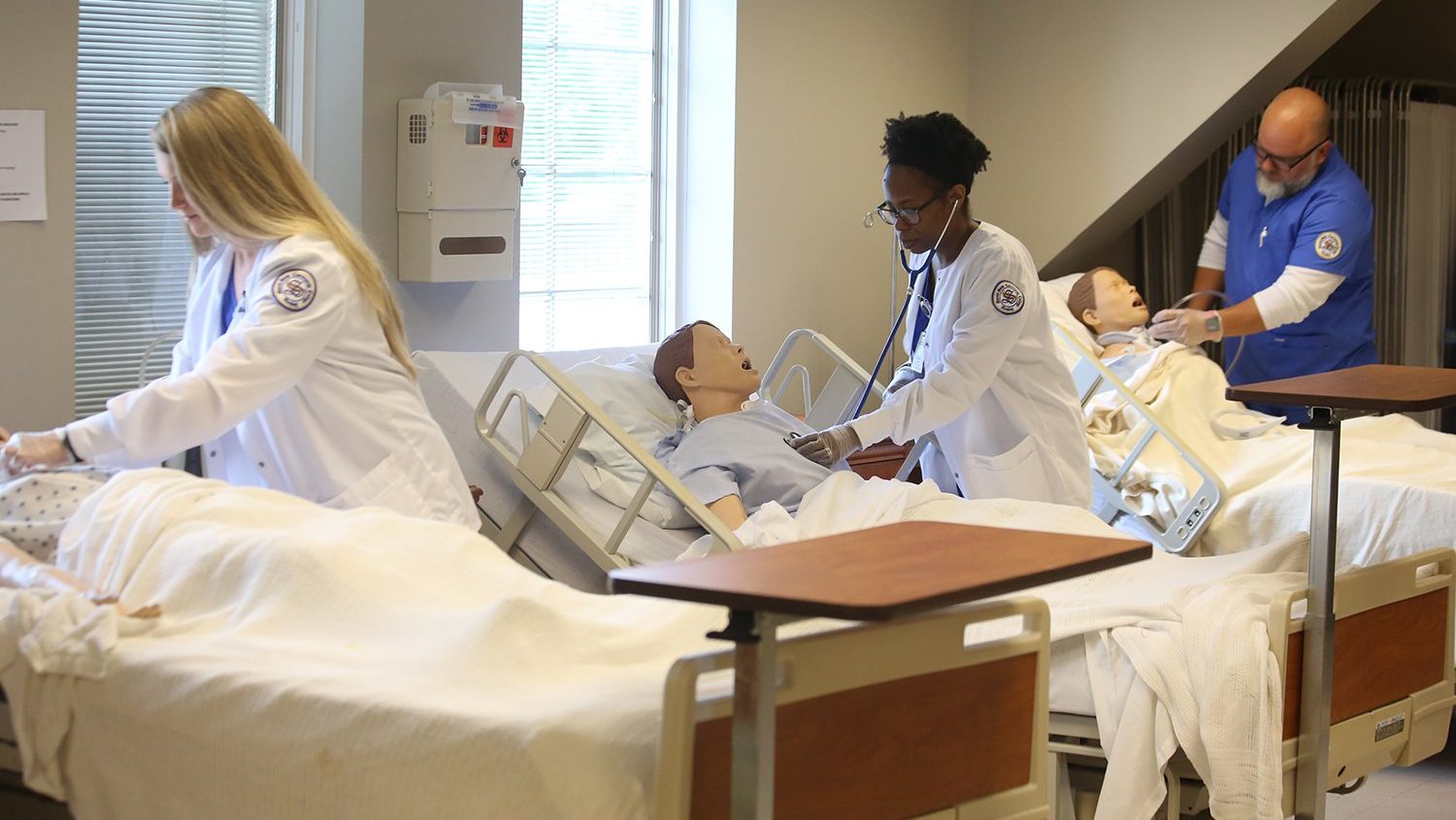 nursing students practicing with mannequins