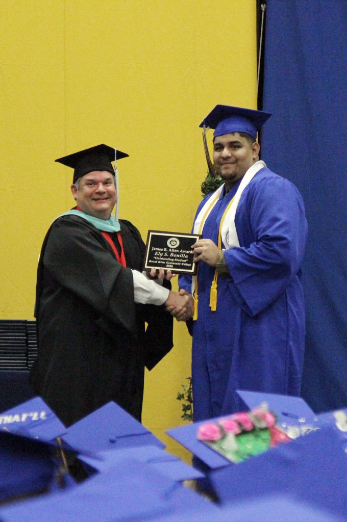 college vice president presents an award to a college graduate